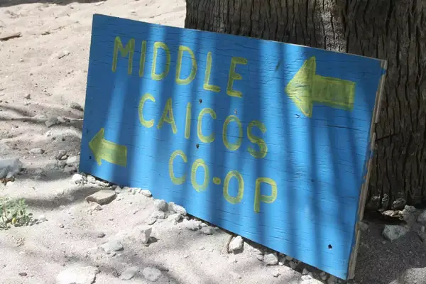 A photograph of a painted wooden sign that reads 