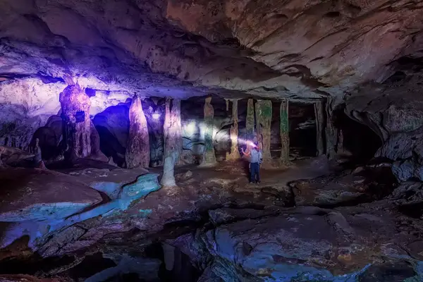 Man spelunking in cave with light. Middle Caicos Indian Caves located on the tiny Turks & Caicos