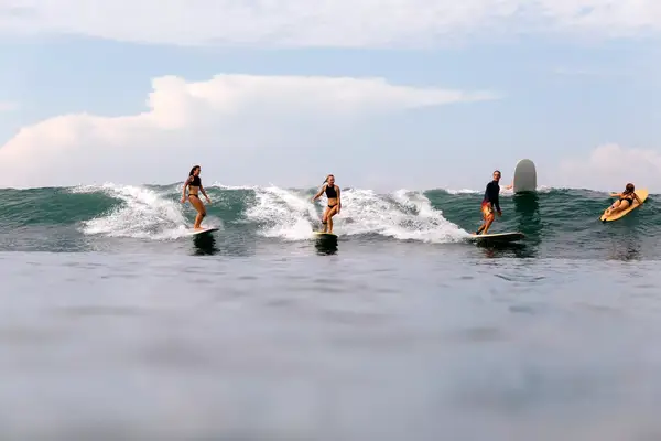 A group of surfers riding the waves in Bali