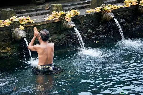 Balinese Hindu devotees perform the Melukat ritual at Tirta Empul Temple