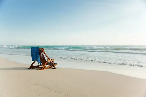 A beach chair on a pristine beach. 