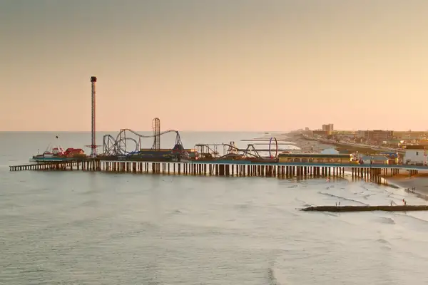 Aerial shot of the historic pier and the beach in Galveston, Texas at sunset. Authorization was obtained from the FAA for this operation in restricted airspace.