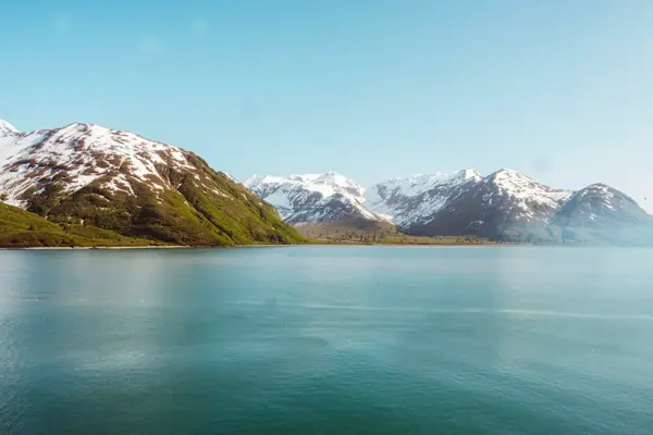 Snow capped mountains along the water