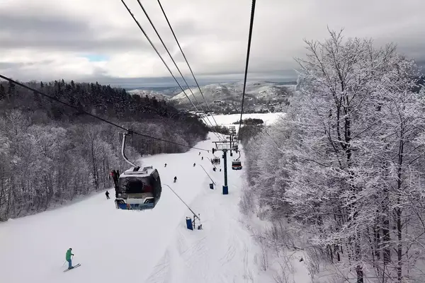 Ski lift glides over top of skieers