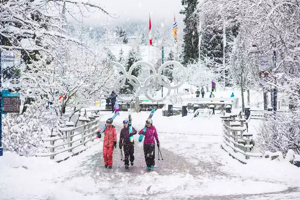 Skiers walking through the Ski Olympic Village at Whistler