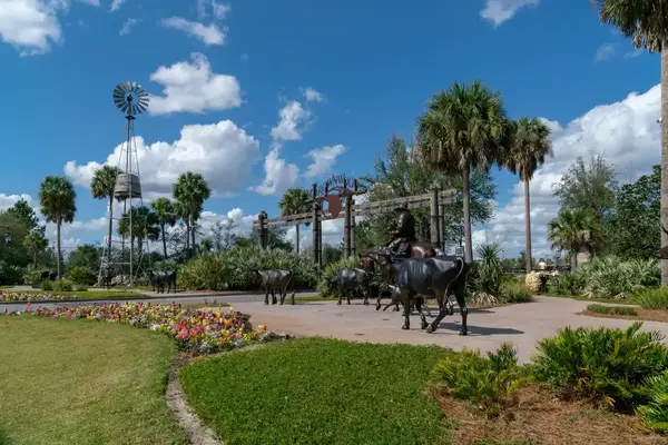 Statues of cattle herding with a background of trees and a windmill
