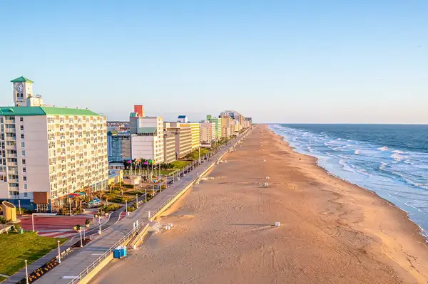 Virginia Beach boardwalk and oceanfront view, with buildings on one side and sandy beach on the other