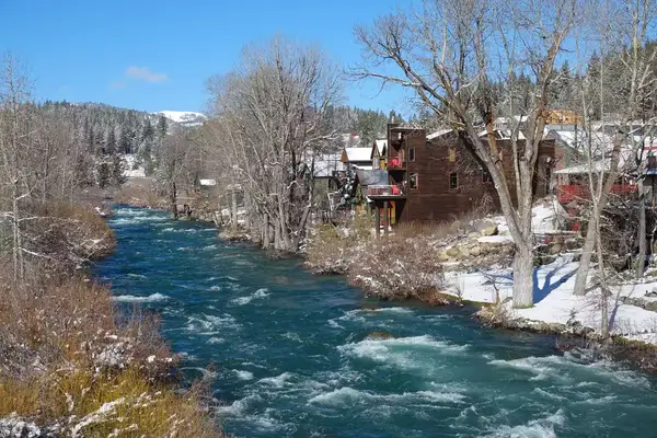 Blue river flowing past old houses in Truckee
