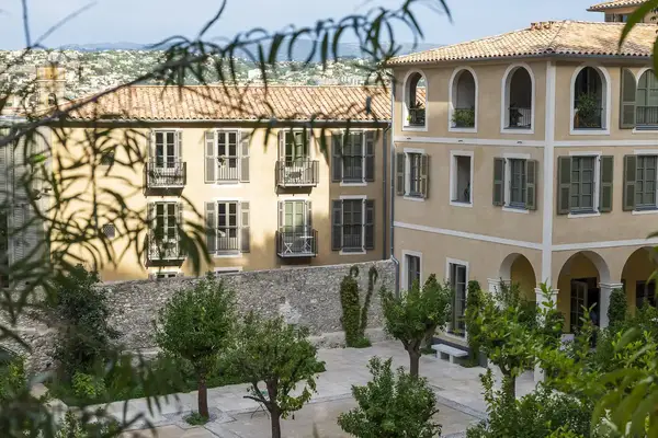 View of a courtyard surrounded by classical European architecture and greenery