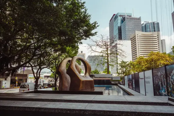 a large public statue in between skyscrapers. 