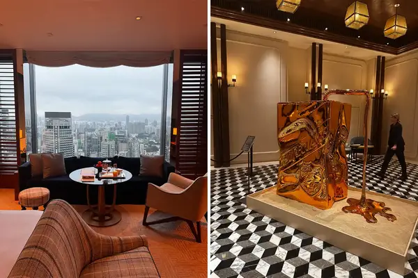 A bedroom with a view of a city skyline and a gold statue on tiled floor.