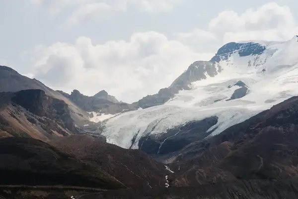 A remote mountain range featuring a prominent glacier