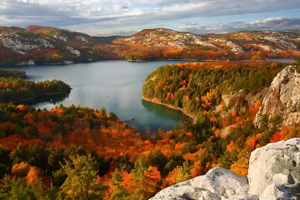 Scenic view of a lake surrounded by autumn foliage and rugged hills in a nature park