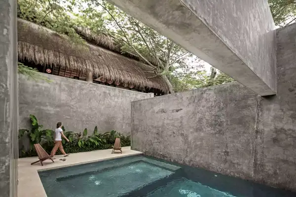 A woman walking past a pool at hotel Casa Hormiga, in Mexico