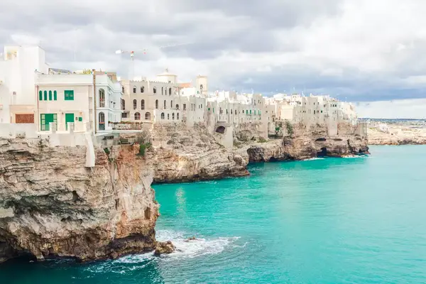 Polignano a Mare antique buildings over rocky shore facing Adriatic Sea, Puglia region, Italy.