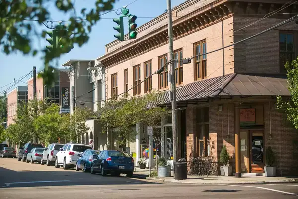 A downtown street lined with cars.