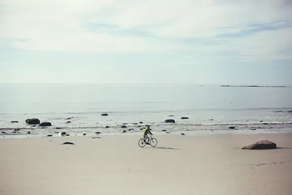 Person riding a bike on the beach.