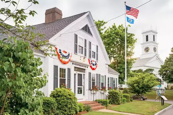 Stock photograph of town hall and pole with US flag in Chatham, Cape Cod, Massachusetts, USA.