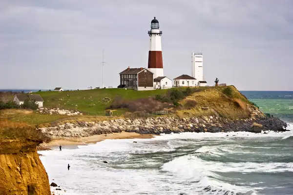 Montauk Point Lighthouse and two fishermen taken from the cliffs of Camp Hero state park located at Montauk Point, Long Island, New York.