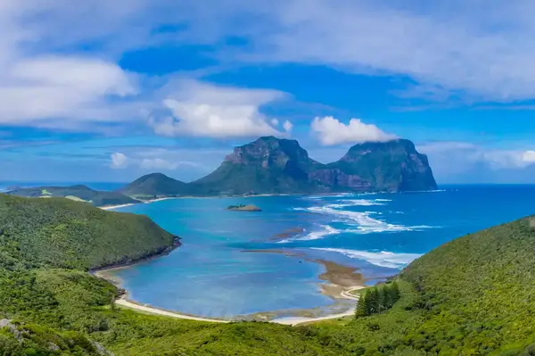 Scenic view of Lord Howe Island with mountains in the background and ocean inlets surrounded by greenery