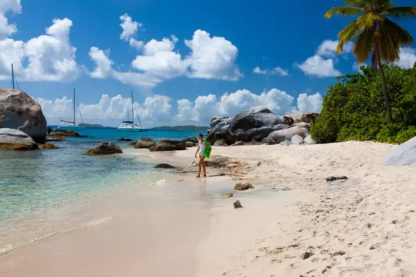 woman walking with snorkel gear at the beach, the baths, virgin gorda, british virgin islands