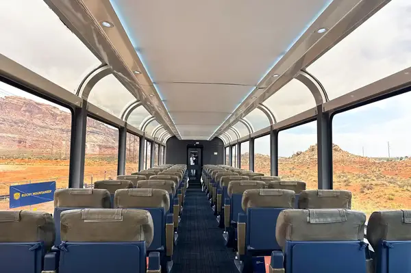 Interior of a train car with large windows and scenic desert landscape outside