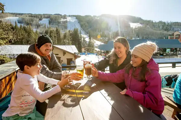 A family of four enjoying apres ski in Vail, Colorado