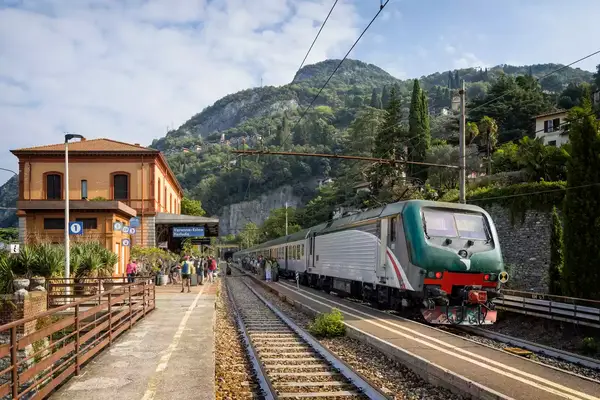 Holidays in Italy - tourists wait on the platform in the tourist town of Varenna on Lake Como
