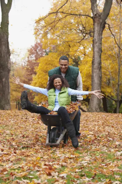 african american man pushing wife in wheelbarrow
