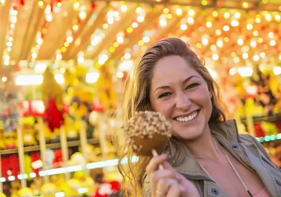 usa, maine, rockland, woman holding caramel apple at funfair