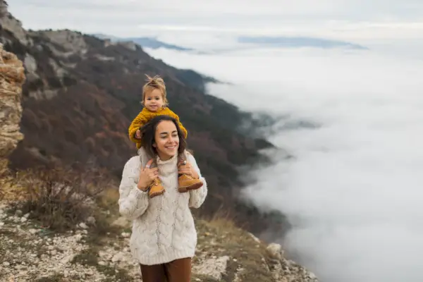 young happy woman with toddler baby daughter enjoying together child sitting on neck simply living and harmony with autumn nature