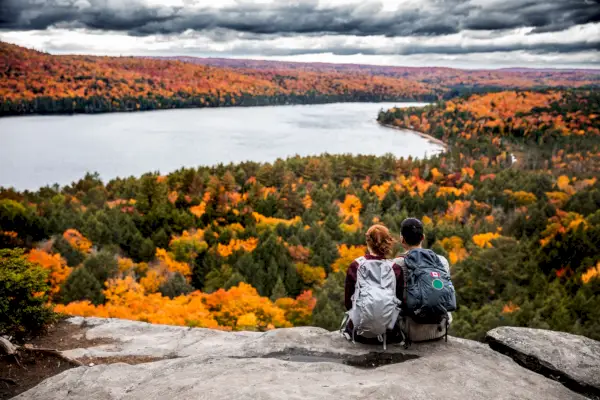 young couple hiking in mountain and relaxing looking at view