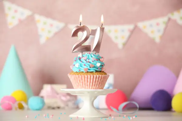 21th birthday cupcake with number candles on white table