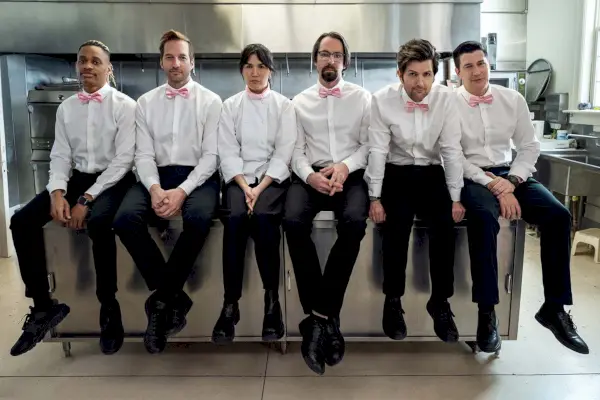 party down season 3 cast in white button ups, pink bows, black pants hanging out in catering kitchen and looking dejected
