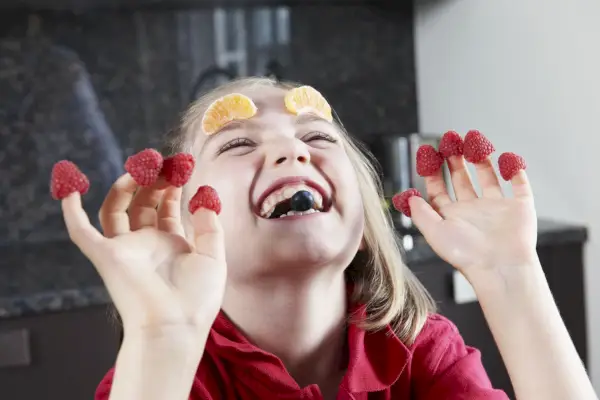 little girl playing with fruit