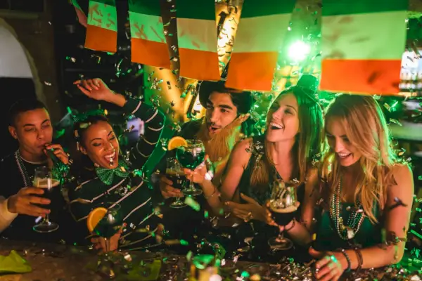 friends partying with drinks and confetti on saint patrick