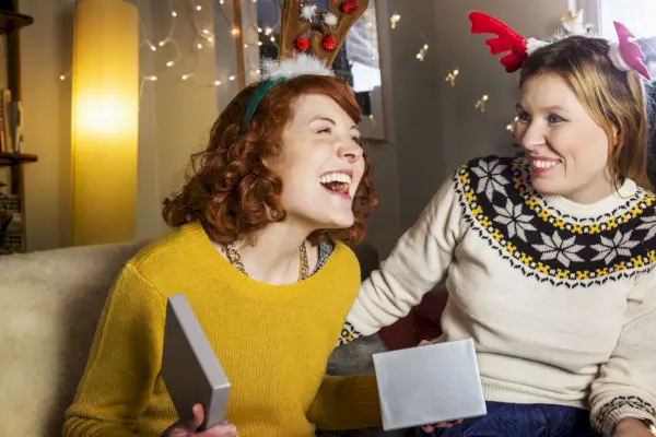 a person holding a phone and another woman holding a book