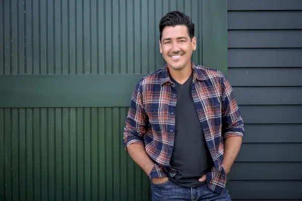 jonathan knight in front of the restored barn at his new england farmhouse, as seen on farmhouse fixer