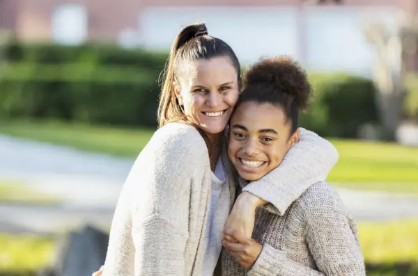 portrait of teenage girl and step mother outdoors
