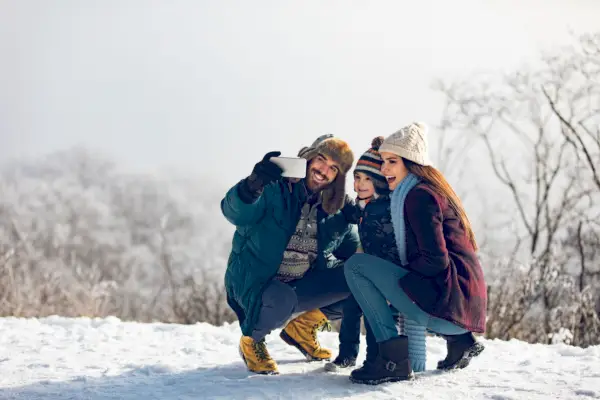 family taking selfie on winter day in the snowy woods