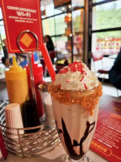 a glass of ice cream with a red straw