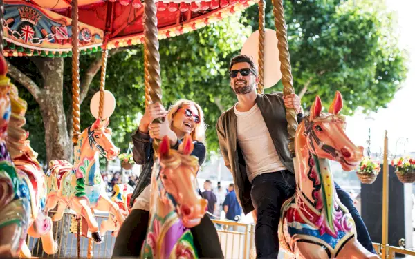 second date ideas couple riding a carousel at park