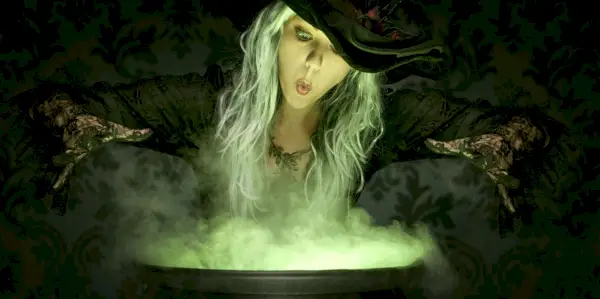 women dressed as witch over cauldron