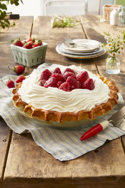 a pie with whipped cream and strawberries on top