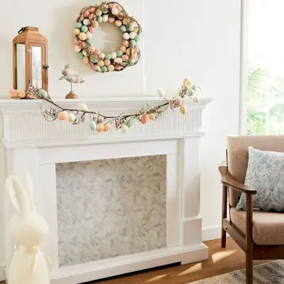 a fireplace decorated for easter with an egg garland and wreath