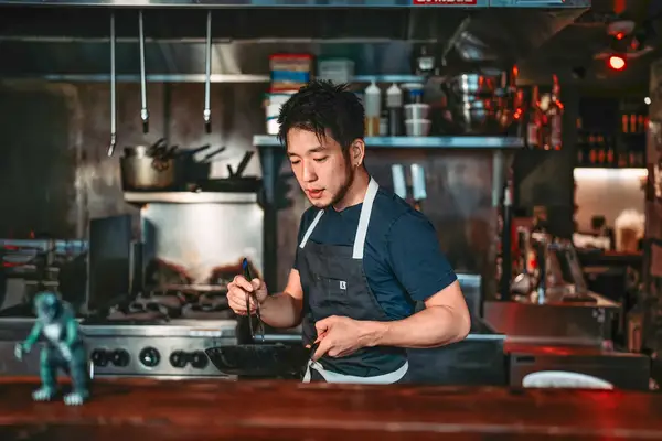 A Japanese chef cooking in his kitchen.