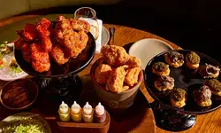An assortment of dishes on a table including fried chicken and other items