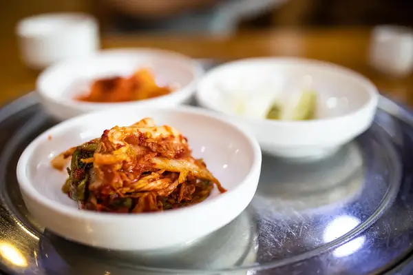 Assorted Korean side dishes served in small bowls on a metal tray
