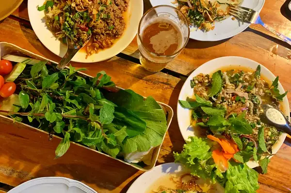 Various dishes of Thai food arranged on a wooden table