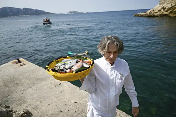 Chef Gerlad Passedat carrying a basket of fish at the port in Marseille